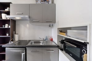 A compact kitchen with a built-in microwave, a sink, and a small refrigerator. - Cosy Villarembert Apartment with Mountain View and Wi-Fi (Villarembert)