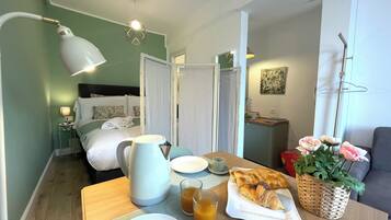 Une table de petit-déjeuner soigneusement dressée, avec une cafetière, des assiettes, des verres et des viennoiseries.