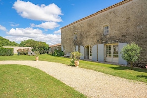 A stone building with a gravel path, a small garden, and a clear blue sky. - Holiday Home 'Maison De Vacances Avec Piscine' with Private Pool, Private Terrace and Wi-Fi (Sainte-Gemme)