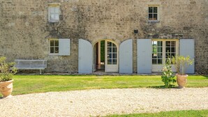 A stone building with a gravel path, a bench, and potted plants. - Holiday Home 'Maison De Vacances Avec Piscine' with Private Pool, Private Terrace and Wi-Fi (Sainte-Gemme)