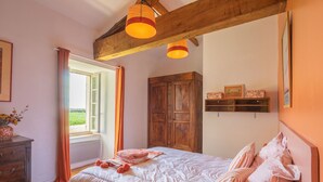 A bedroom with a bed, wooden wardrobe, and a window with curtains. - Holiday Home 'Maison De Vacances Avec Piscine' with Private Pool, Private Terrace and Wi-Fi (Sainte-Gemme)