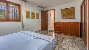 Ein Schlafzimmer mit einem Bett, einem Holzschrank, einer Tür und einer an der Wand befestigten Karte.