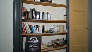 A bookshelf with various books and a sign with French text. - Guest House 'Jolie Chambre Au Calme À Auzat' with Mountain View (Auzat)