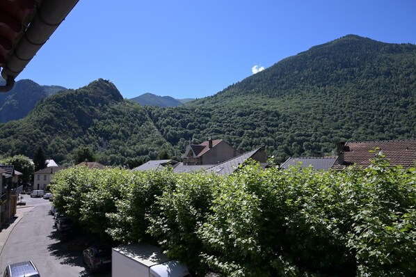 A residential street with houses, a mountain backdrop, and a clear sky.
