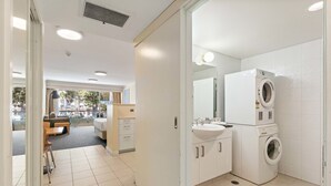 A modern bathroom with a washing machine, a sink, and a mirror. - Manly Seabreeze With 1 Bathrooms (Manly)