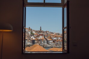 Vista a través de una ventana de un paisaje urbano con edificios y una torre destacada.
