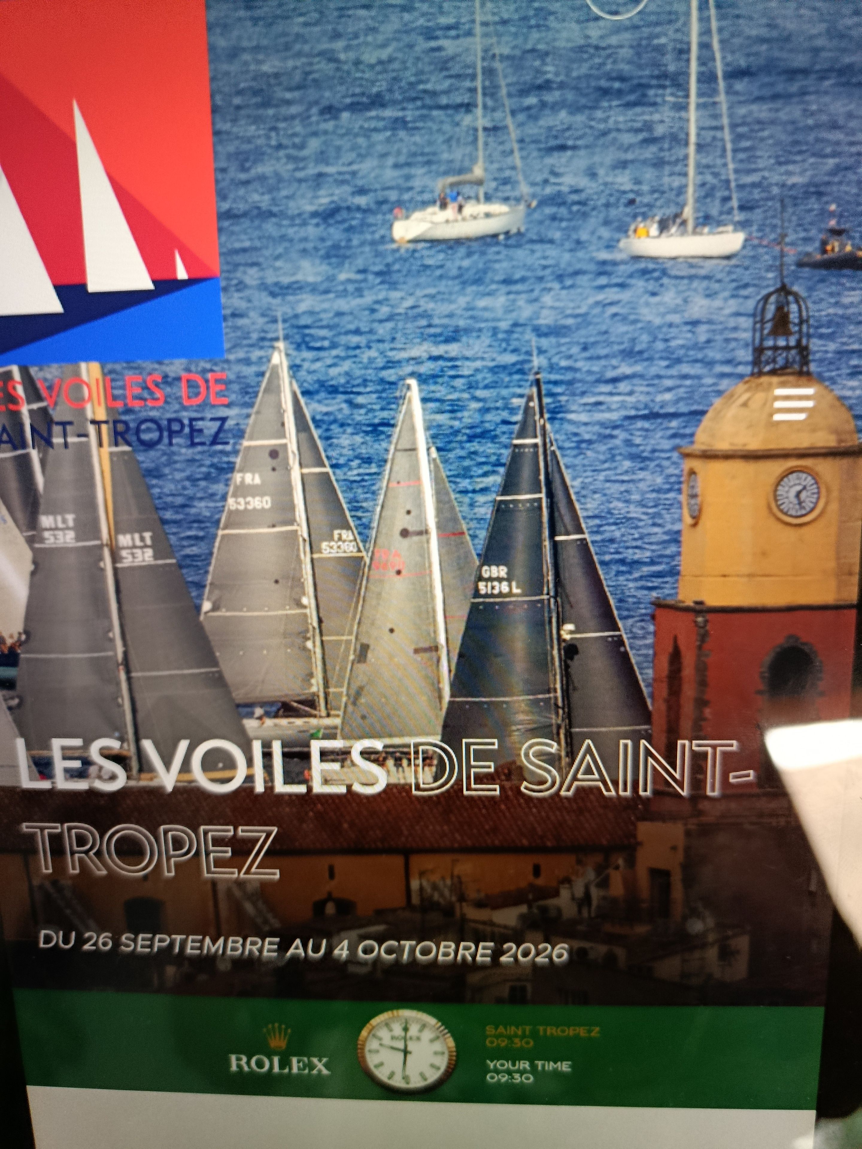 Une affiche représentant des voiliers sur l’eau, un beffroi et un texte indiquant qu’un événement se déroule à Saint-Tropez.