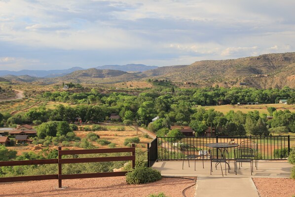Sit and take in the breathtaking mountain views from a serene outdoor space with a bench and dining area.