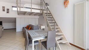 A compact apartment with a loft bedroom, a dining area, and a kitchen. - Cozy Mezzanine Apartment by Wonderful Italy (Bologna)