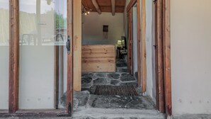 A wooden entryway leading to a stone staircase and a bedroom with a bed and a nightstand.