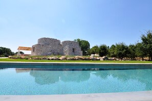 Una piscina amb una estructura de pedra al fons.