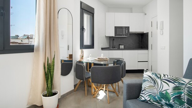 A compact living space with a dining area, kitchenette, and a sofa. - Apartment 'Cervantes Homes No3' with Shared Terrace, Wi-Fi and Air Conditioning (Conil de la Frontera)