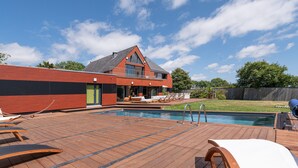 Una casa moderna con piscina, terrazza e area relax all'aperto.