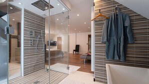 Un bagno moderno con box doccia in vetro, vasca da bagno e porta asciugamani.