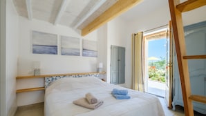 A bedroom with a bed, a nightstand, a wardrobe, and a view of the outdoors. - Villa 'Propriété Fontaine Margo': Peaceful Retreat with Mountain Views (Seillans)