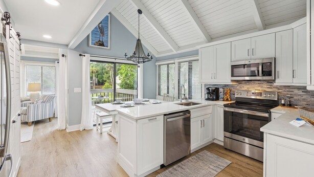 Una cocina moderna con armarios blancos, electrodomésticos de acero inoxidable y una isla grande.