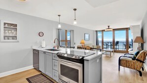 Cocina moderna con isla central, horno empotrado y comedor con vistas.