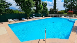 Una piscina rectangular con superficie de agua azul cristalina, rodeada por una solería.