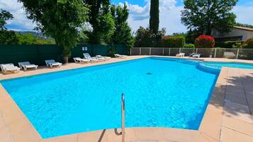 Une piscine rectangulaire à l’eau d’un bleu limpide, entourée d’une terrasse carrelée.