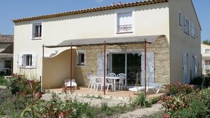 Edificio de dos pisos con un patio amoblado al aire libre.