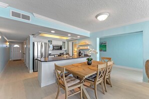 Enjoy meals in the kitchen with a central island and dining area featuring a table and chairs.