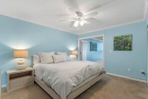 Cozy retreat with a single bed, ceiling fan, and wall-mounted lamp.