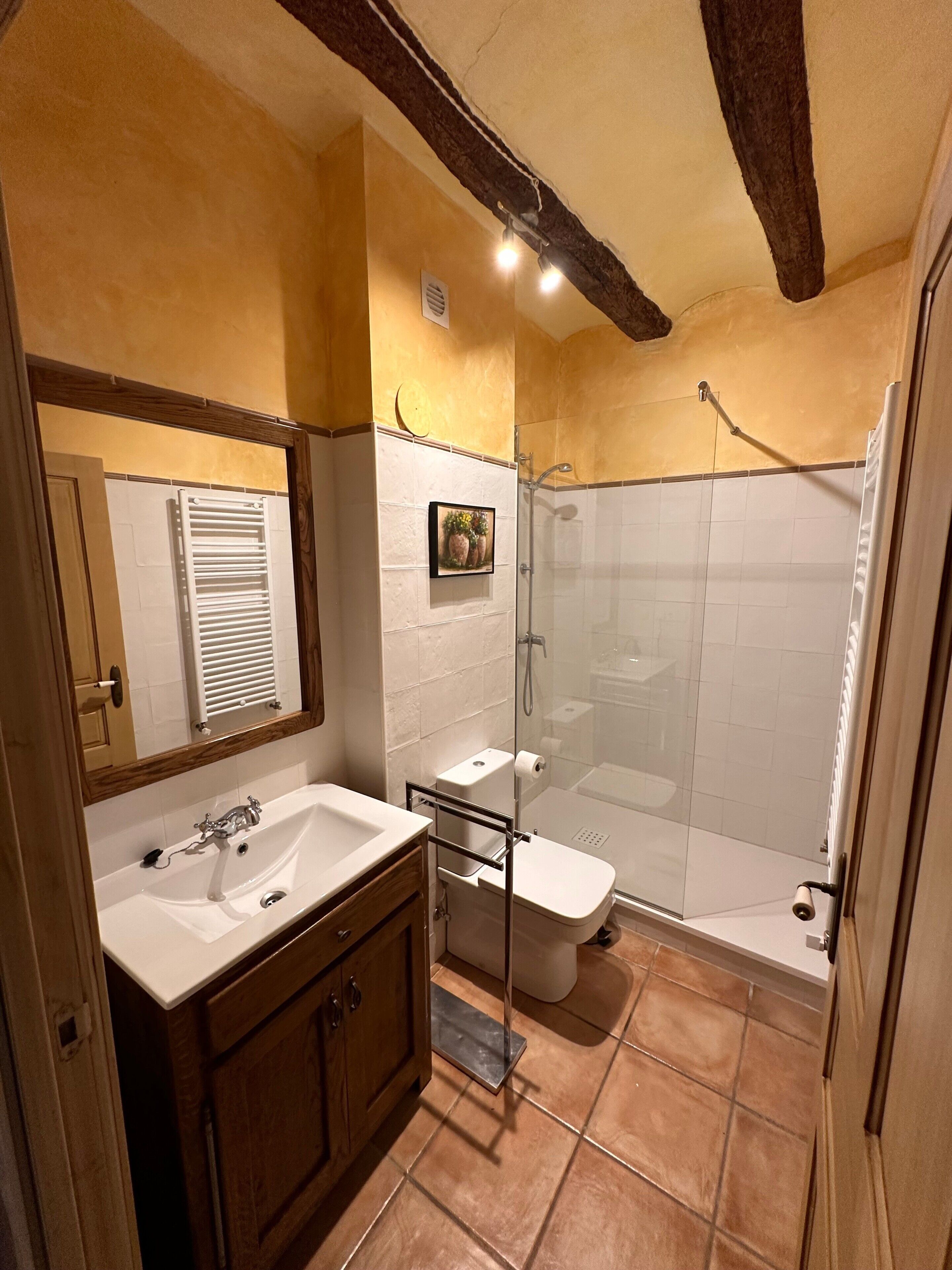 A bathroom with a sink, toilet, and shower.