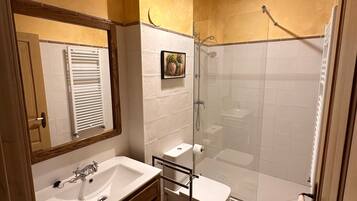 A bathroom with a sink, toilet, and shower.