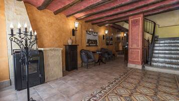 A cozy interior with a fireplace, seating area, and a staircase.