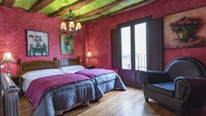 Una stanza con un letto, una sedia, un termosifone e una finestra vista.