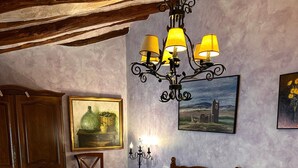 A bedroom with a large bed, wooden headboard, a chandelier, and two paintings on the wall. - Suite 'Las Golondrinas' with Mountain Views and Unlimited SPA Access with Cellar (Lerín)