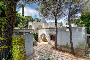 Eine Villa mit Innenhof, Rundbogenportalen und einer Treppe, die zu einer zweiten Ebene führt.