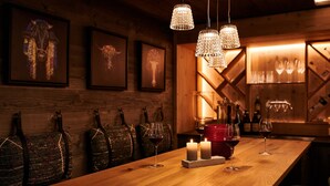 A wooden bar area with hanging lights, candles, and wine glasses. - Chalet Evi - TOP 1 (Kaprun)