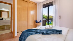 A bedroom with a large bed, a wooden wardrobe, a window with curtains, and a view of greenery outside. - Charming Casa Tara: Experience the Magic of Your Perfect Getaway in Paradise (lajares)