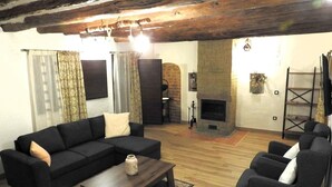 A living room with a fireplace, sofas, and a coffee table. - Country House 'Casa Larralde' with Shared Pool, Wi-Fi and Air Conditioning (Bisimbre)