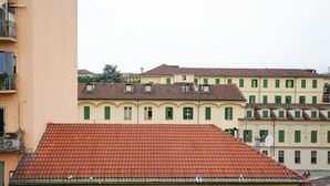 Ein Gebäude mit rotem Ziegeldach, grünen Fensterläden und einer gelben Fassade.