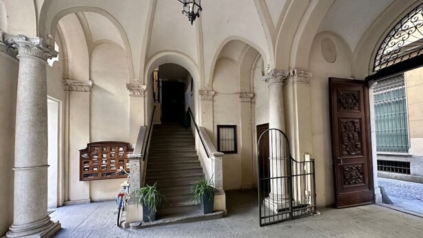 A grand entrance with a staircase, columns, and a decorative door. - Torino Centro, Romano Suite (Torino)