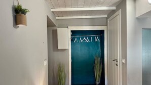 A hallway with a teal door, a hanging plant, and a lamp. - Torino Centro, Romano Suite (Torino)