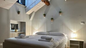 A modern bedroom with a large bed, skylight, and built-in shelving. - Torino Centro, Romano Suite (Torino)