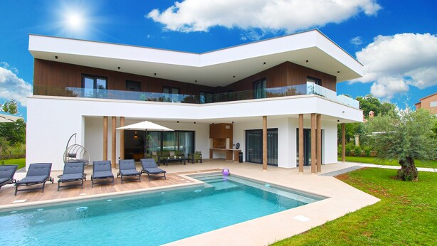 A modern two-story house with a swimming pool, outdoor seating, and a well-maintained garden.