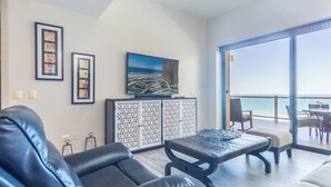 Una sala de estar moderna con un sofá de cuero, una mesa de centro y un ventanal con vista al océano.