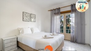 Ein Schlafzimmer mit einem Bett, einem Nachttisch und zwei Wandbildern.
