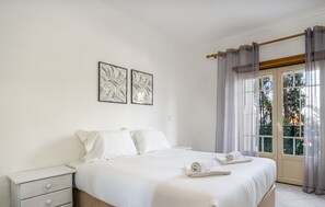 A bedroom with a bed, a nightstand, and two wall art pieces.