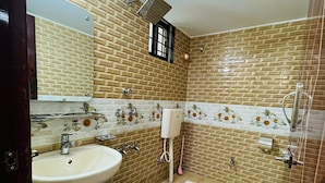 A bathroom with a sink, mirror, and shower. - Saudia residential hotel (Sylhet)