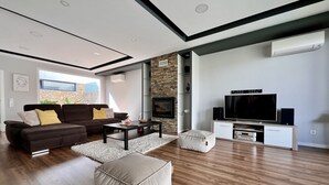 A modern living room with a sofa, coffee table, ottoman, TV, and entertainment unit. - Casa Giumeni - House with swimming pool (Fernão Ferro)