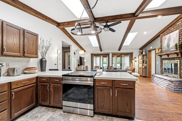 A spacious kitchen with wooden cabinets, a large island, and a built-in oven.