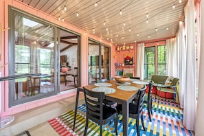 A dining area with a wooden table, chairs, and a colorful floor pattern.