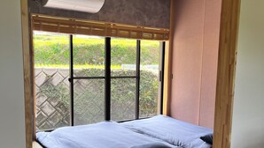 Une chambre à coucher avec un lit, une fenêtre et une petite table.