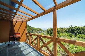 A wooden balcony with a view of a vineyard and distant mountains. - Imogawa Lodge (Ukiha)