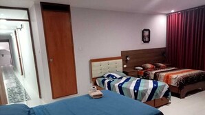 A hotel room with a large bed, a smaller bed, and a desk. There is a door and a window with curtains. - HOTEL D MARTIN (Coishco)